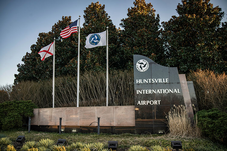 3 flags waving at the entrance to the Huntsville International Airport in Alabama.