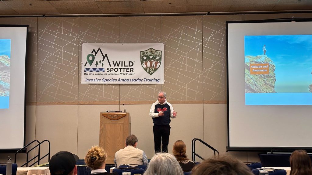 Speaker is standing next to a podium.