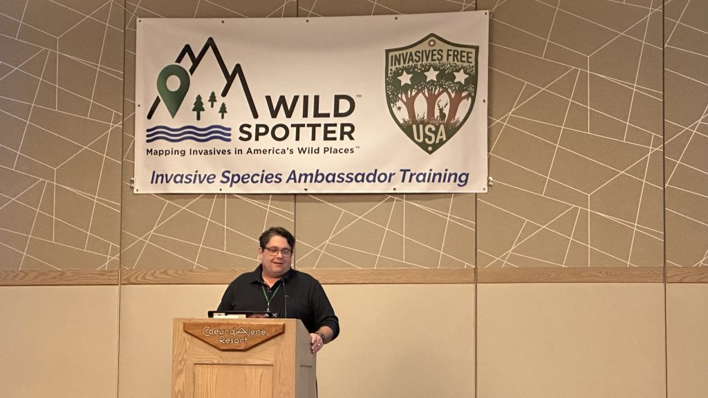 Speaker is standing next to a podium.